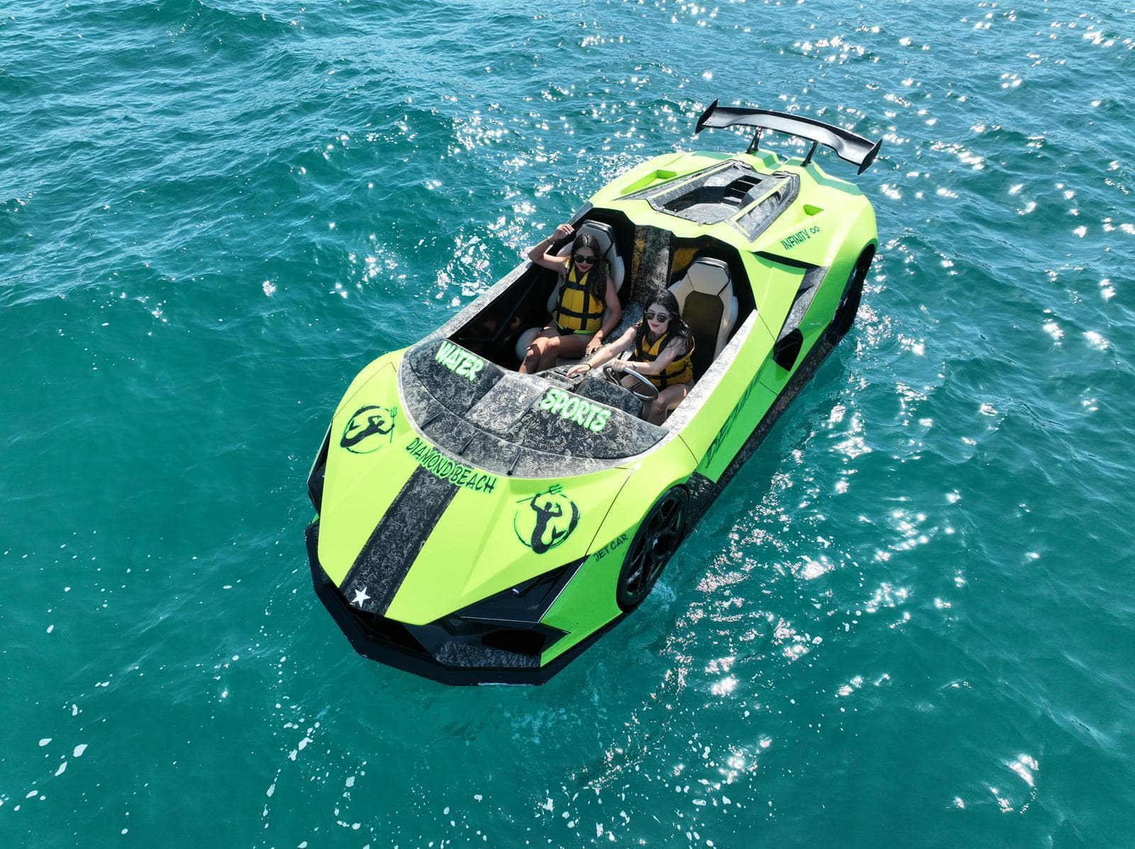 Guests taking a green jet car out across clear turquoise water